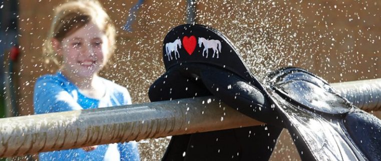 乗馬鞍を洗う少女